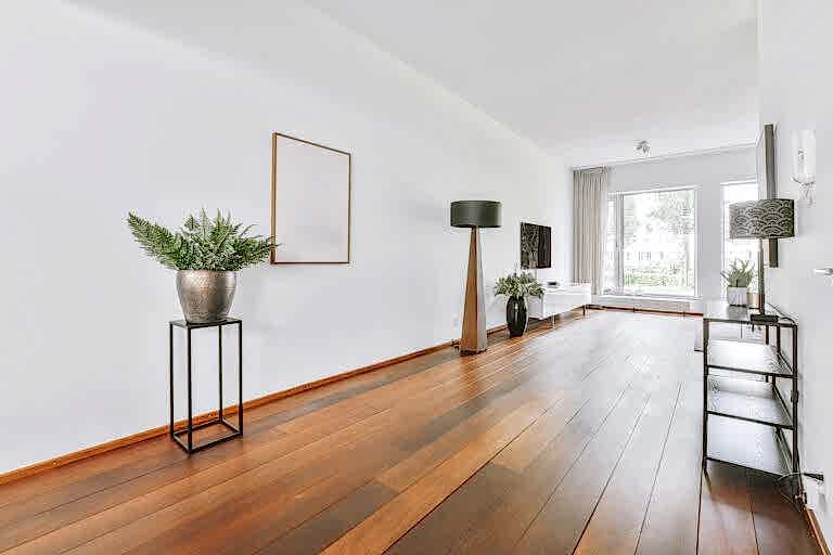 Interior of living room with comfortable sofa and TV against windows in contemporary apartment